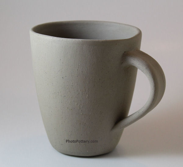Coffee cup hand-built on plaster mold using slabs with slip and score. Porcelain clay, greenware